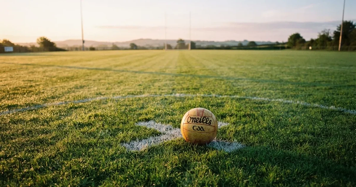 A ball on the centre spot of a grass pitch in morning light