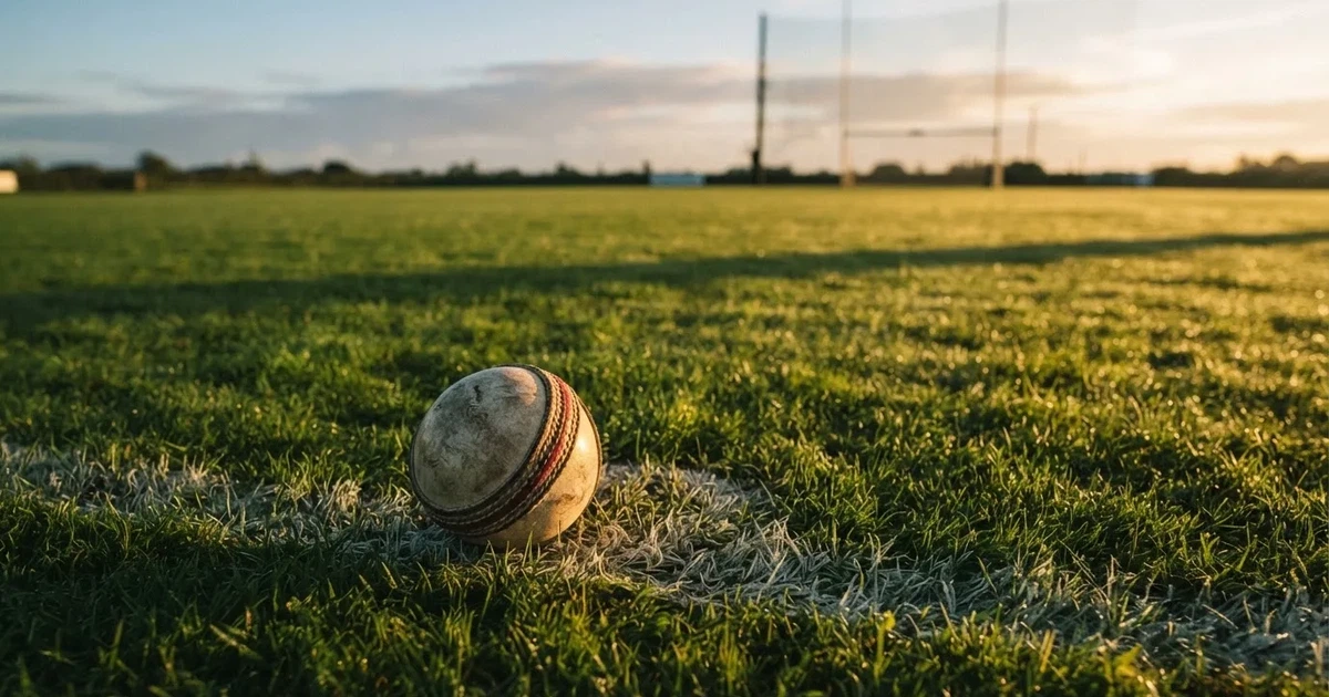 A ball on the centre spot of a grass pitch in morning light