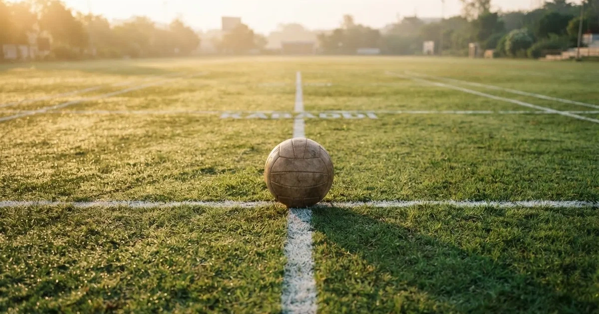 A ball on the centre spot of a grass pitch in morning light