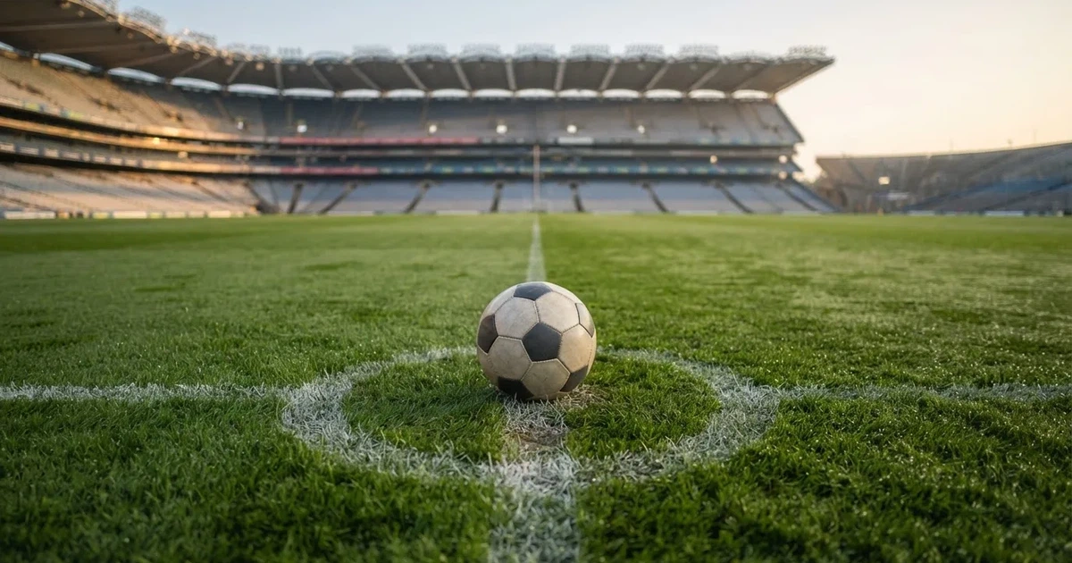 A ball on the centre spot of a grass pitch in morning light